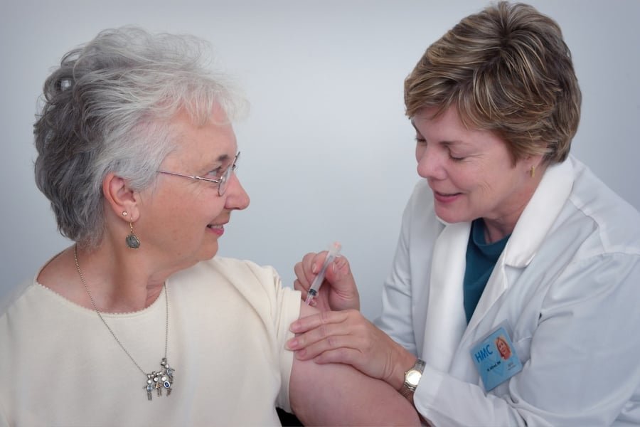 Indian nurse providing affectionate bedside care to an elderly patient at home